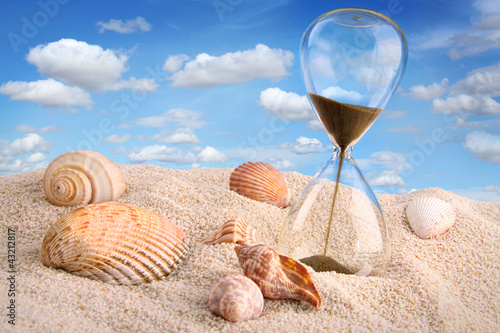 Photo: Hourglass in the sand with blue sky Hourglass in the sand with blue sky