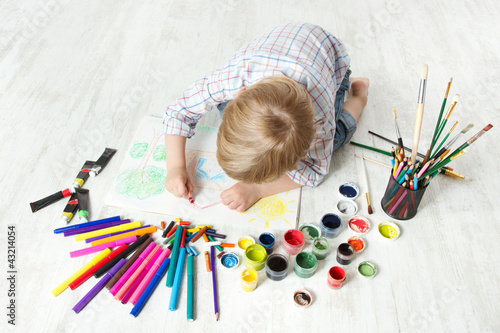 Photo: Child drawing picture with crayon in album using a lot of paint Child drawing picture with crayon in album using a lot of paint