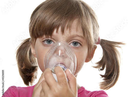 Photo: little girl using inhaler - respiratory problems little girl using inhaler - respiratory problems