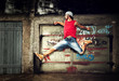 Young man jumping, dancing on grunge wall