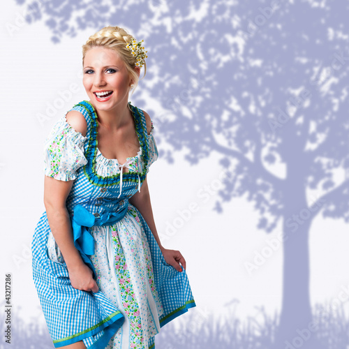 Foto: junge blonde Frau im Dirndl vor gemaltem Hintergrund junge blonde Frau im Dirndl vor gemaltem Hintergrund