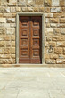 elegant wooden door and stone wall, detail of facade in Florence