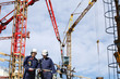 engineers inside construction site, cranes and scaffolding