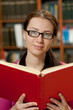 Photo: girl in library with book girl in library with book
