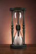 Hourglass with white sand on dark background 