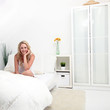 Friendly smiling attractive girl in a white bedroom