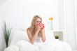 Woman sitting in bed enjoying coffee