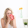 Photo: Young woman drinking coffee in bed Young woman drinking coffee in bed