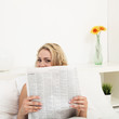 Young woman reading morning newspaper
