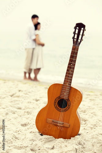 Photo: Couple kissing at the beach and guitar. Couple kissing at the beach and guitar.