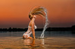 sexy blonde woman in water at sunset .Beautiful swimsuit model