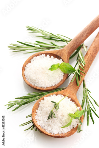 Photo: salt in spoons with fresh basil, thyme and rosemary isolated salt in spoons with fresh basil, thyme and rosemary isolated