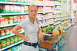 Frau mit Einkaufswagen im Supermarkt