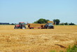 Photo: tractors load bales of hay in farmlands tractors load bales of hay in farmlands