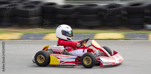 Photo: Young asian boy racing in a go kart Young asian boy racing in a go kart