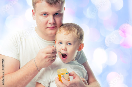 Photo: man feeding baby with a spoon man feeding baby with a spoon