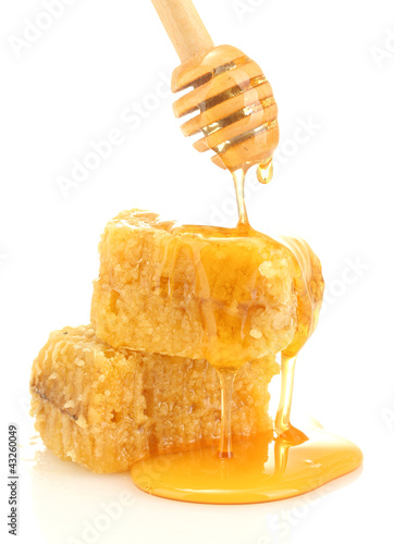Foto: golden honeycombs and wooden drizzler with honey isolated golden honeycombs and wooden drizzler with honey isolated
