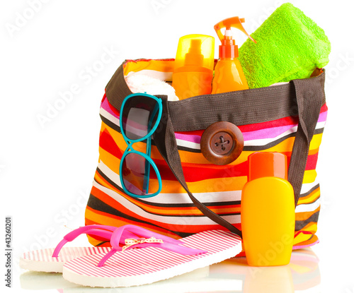 Photo: Beach bag with beach accessories, isolated on white Beach bag with beach accessories, isolated on white