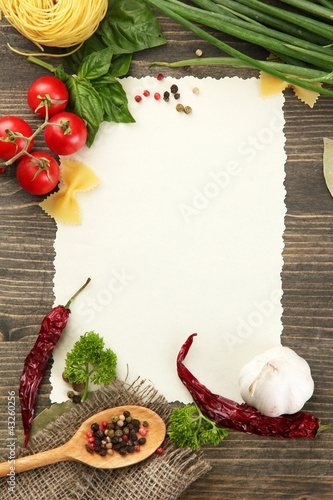 Foto: paper for recipes vegetables, and spices on wooden table paper for recipes vegetables, and spices on wooden table