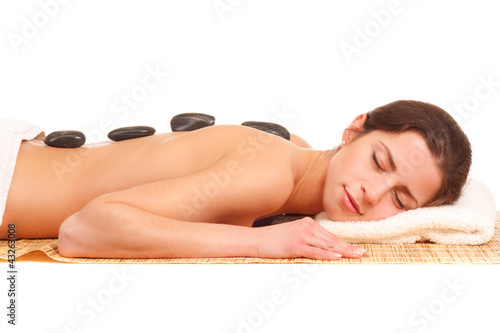 Foto: junge frau mit massagesteinen auf dem rücken junge frau mit massagesteinen auf dem rücken