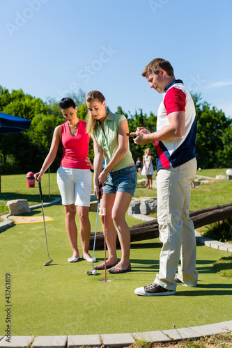 Photo: Leute spielen Minigolf im Sommer Leute spielen Minigolf im Sommer