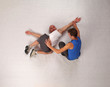 muscular man stretching with personal trainer in studio