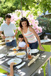 Father serving grilled meat to family
