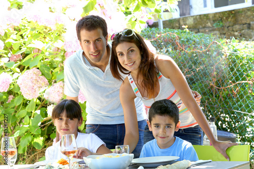 Photo: Closeup of happy family having lunch in garden Closeup of happy family having lunch in garden