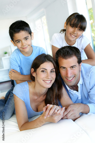 Foto: Portrait of happy family laying down bed Portrait of happy family laying down bed