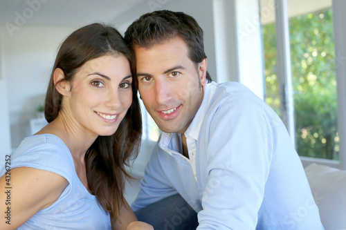 Photo: Closeup of cheerful couple sitting in sofa Closeup of cheerful couple sitting in sofa