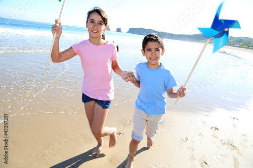 Photo: Kids running on the beach with swirls Kids running on the beach with swirls