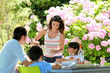 Woman serving water to family having lunch