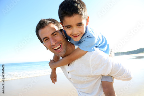 Photo: Father holding son on his shoulders at the beach Father holding son on his shoulders at the beach