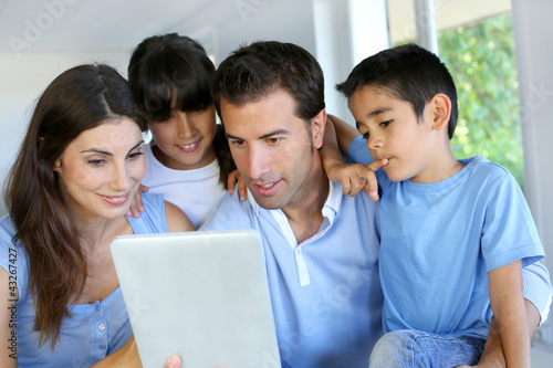 Foto: Parents and children using electronic tablet at home Parents and children using electronic tablet at home