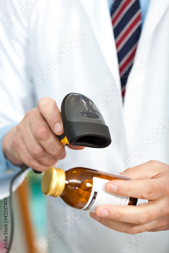 Photo: Man checking a barcode on a pill bottle Man checking a barcode on a pill bottle