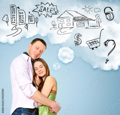 Photo: Smiling beautiful couple standing and embracing. Woman dreaming Smiling beautiful couple standing and embracing. Woman dreaming