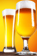 Photo: Beer into glass on golden background Beer into glass on golden background
