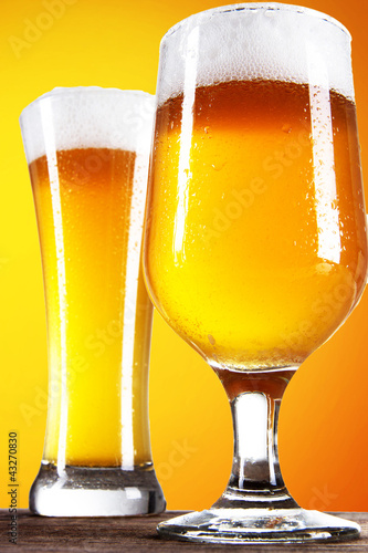 Foto: Beer into glass on golden background Beer into glass on golden background