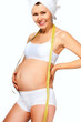 pregnant woman measures her stomach