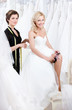 Future bride in wedding gown puts the garter