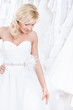 Youg girl is trying on a charming wedding gown, white background