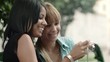 Happy young women looking at pictures on snapshot camera