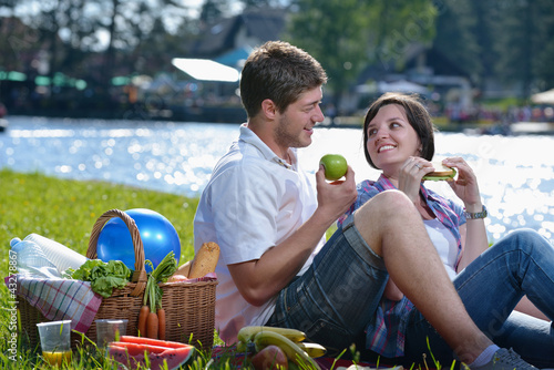 Photo: happy young couple having a picnic outdoor happy young couple having a picnic outdoor