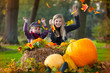 two girls playing with autumn leaves