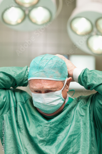 Photo: Surgeon putting on a face mask on his head Surgeon putting on a face mask on his head