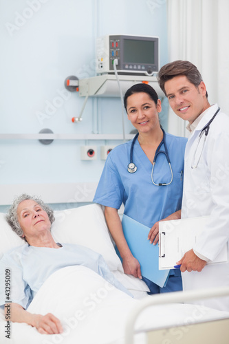 Foto: Patient with her doctor and nurse looking at camera Patient with her doctor and nurse looking at camera