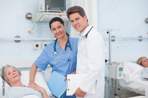 Photo: Doctor and nurse next to a patient Doctor and nurse next to a patient