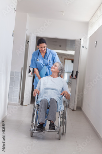 Photo: Nurse pushing a patient in a wheelchair Nurse pushing a patient in a wheelchair