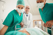Doctors looking at a patient while leaning on a bed