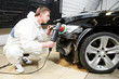 mechanic repairing and polishing car headlight